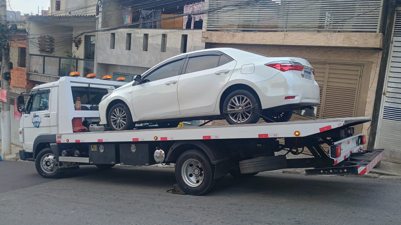 Toyota Corolla branco transportado em guincho prancha em São Paulo